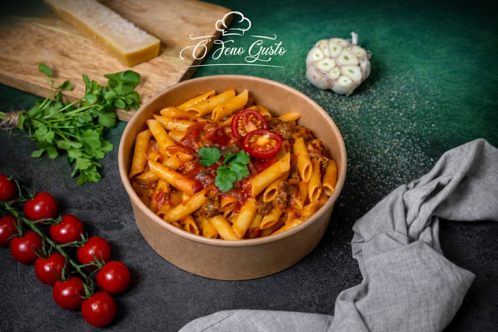 Bol de penne à la sauce tomate maison, garni de persil frais et tomates cerises, servi dans un bol en kraft — Ô'Feno Gusto